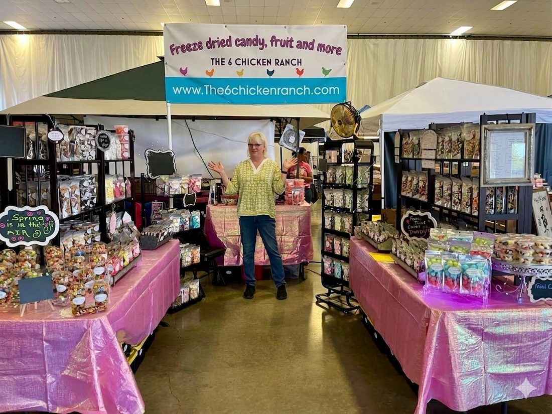 The 6 Chicken Ranch market booth — tables of freeze-dried candy and treats